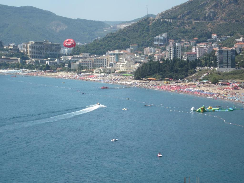 a beach with a bunch of people in the water at Apartments Danilo Kažanegra in Sveti Stefan