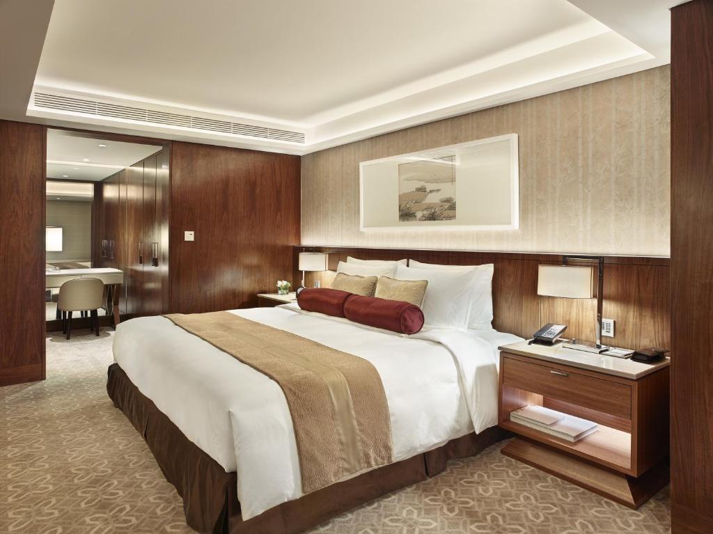 a large bedroom with a large bed and a desk at White Swan Hotel in Guangzhou