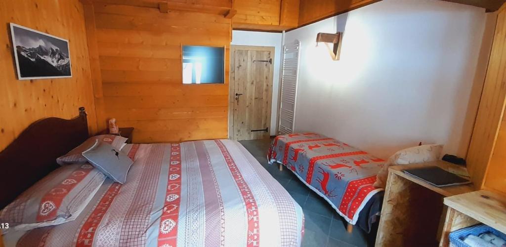 1 dormitorio con 2 camas en una cabaña en Il Maiolandro, en Noasca