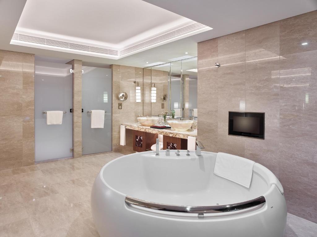 a large bathroom with a white tub and a tv at White Swan Hotel in Guangzhou