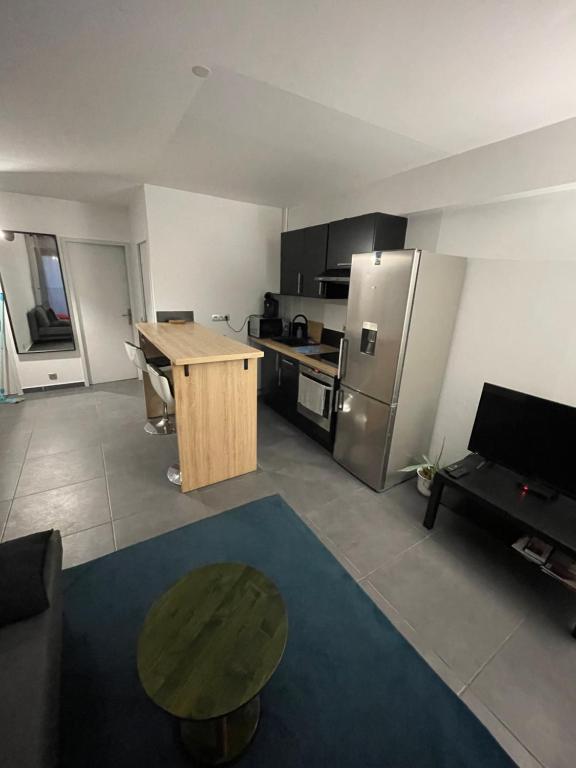 un salon avec une table et une cuisine dans l'établissement Appartement moderne face gare St Charles, à Marseille