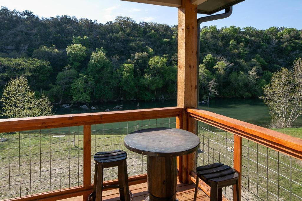 a porch with a table and two stools on a balcony at Lazy Southern Getaway in Canyon Lake