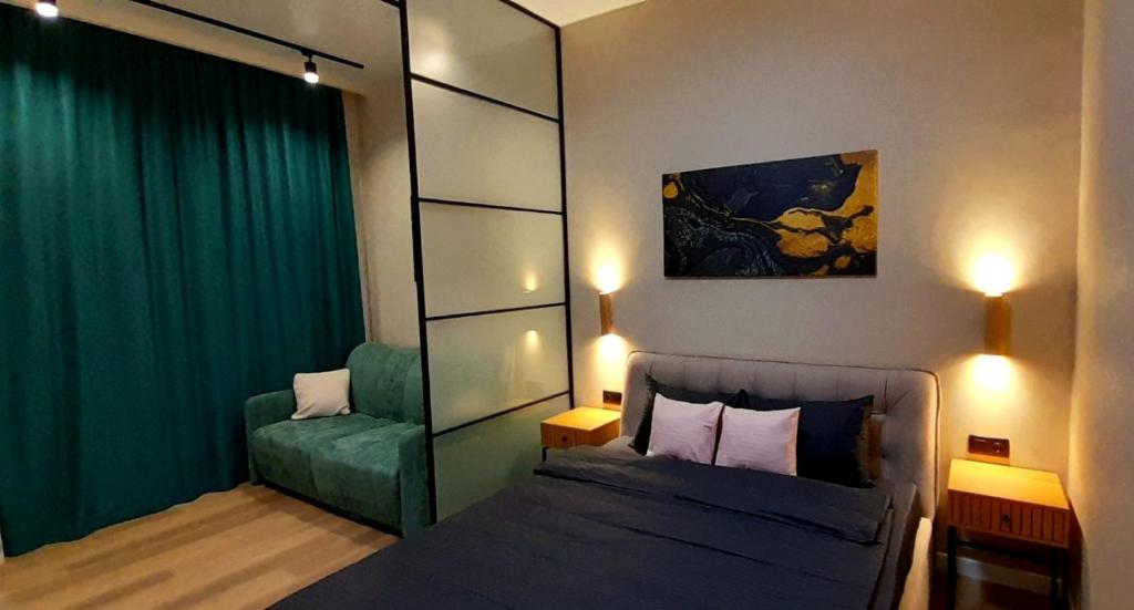 een slaapkamer met een bed en een groene bank bij Apartments in Galicia in Lviv