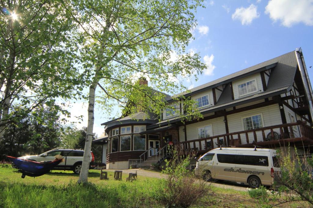 a house with a hammock in front of it at Lodge Clubman in Hachimantai