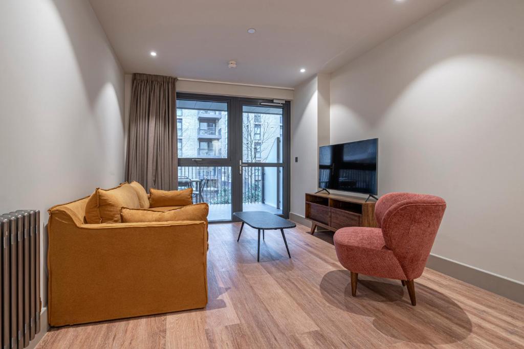 a living room with a couch and a chair and a television at The Sessile in London