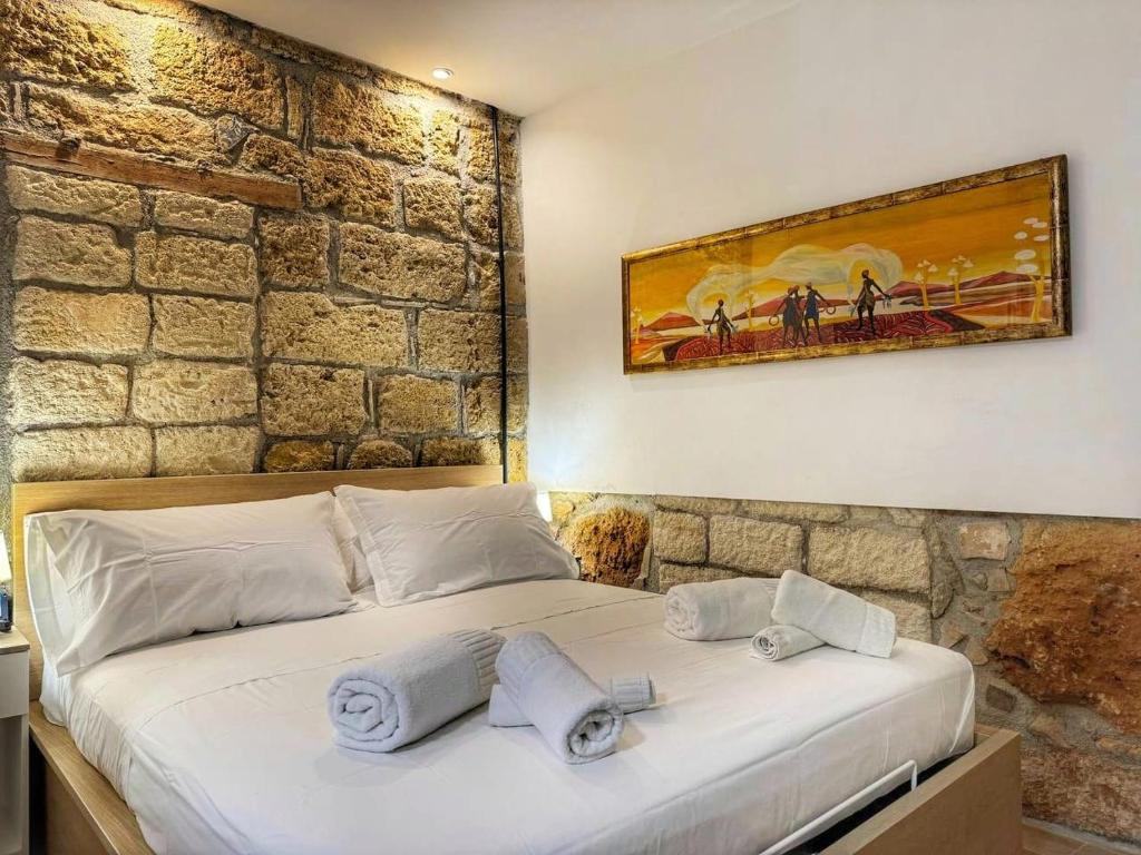 een slaapkamer met een groot bed met handdoeken erop bij MaMa5 in Palermo