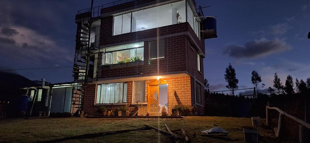 een huis wordt 's nachts verlicht bij Casa y mirador in Otavalo