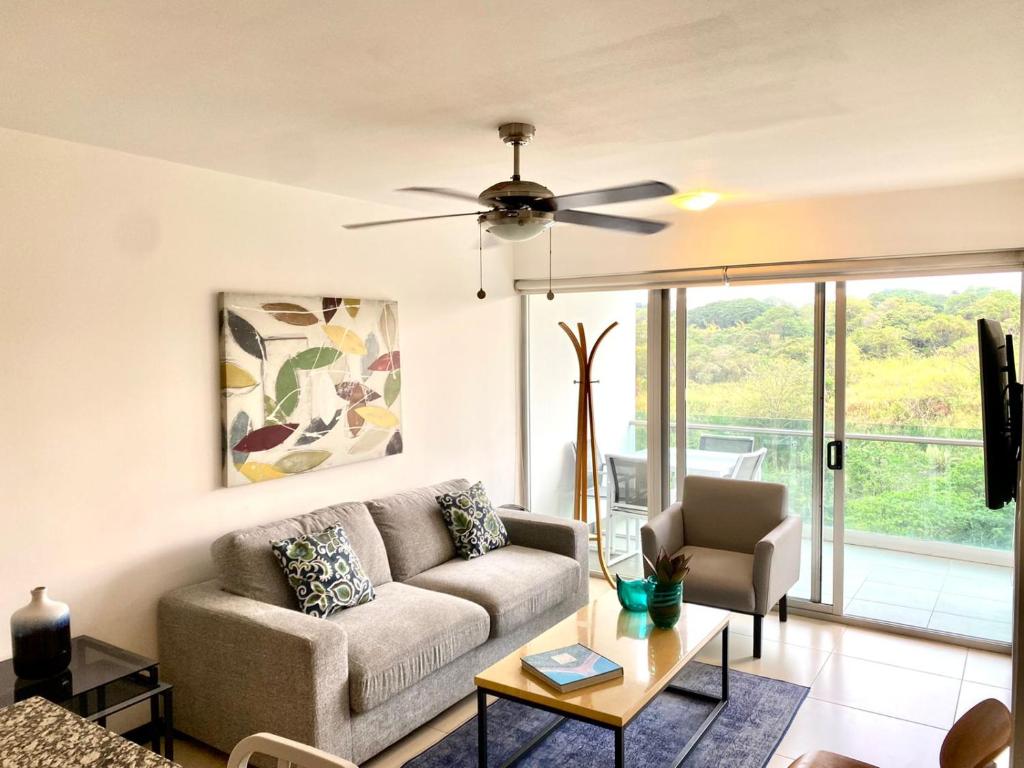 a living room with a couch and a ceiling fan at Charming two bedroom apartment in San José