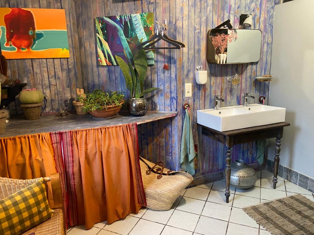 ein Badezimmer mit einem Waschbecken und einer Theke mit Pflanzen in der Unterkunft Dealettante glamping in Bétaucourt