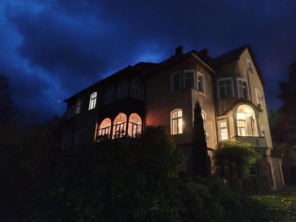 a large house with its lights on at night at Apartament Piastowski in Świeradów-Zdrój