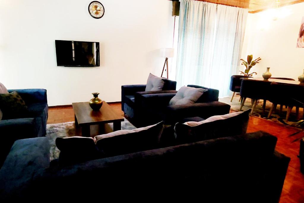 una sala de estar con 2 sofás y un piano en A Spacious 4BR 2 Bathroom Villa House @ Bole DT en Addis Abeba
