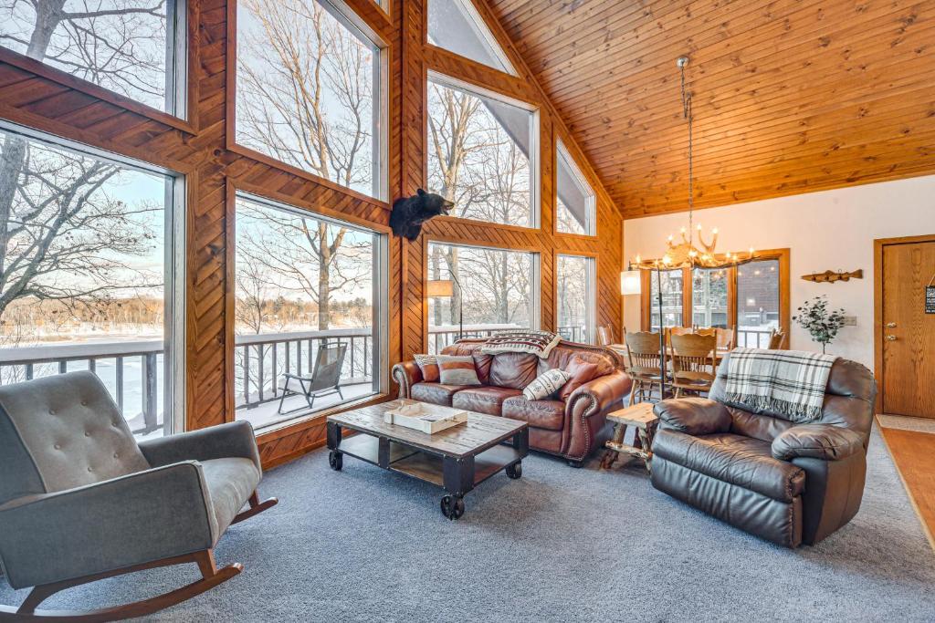 a living room with furniture and a large window at Rice Lake Cabin Retreat with Red Cedar Lake Access! in Rice Lake