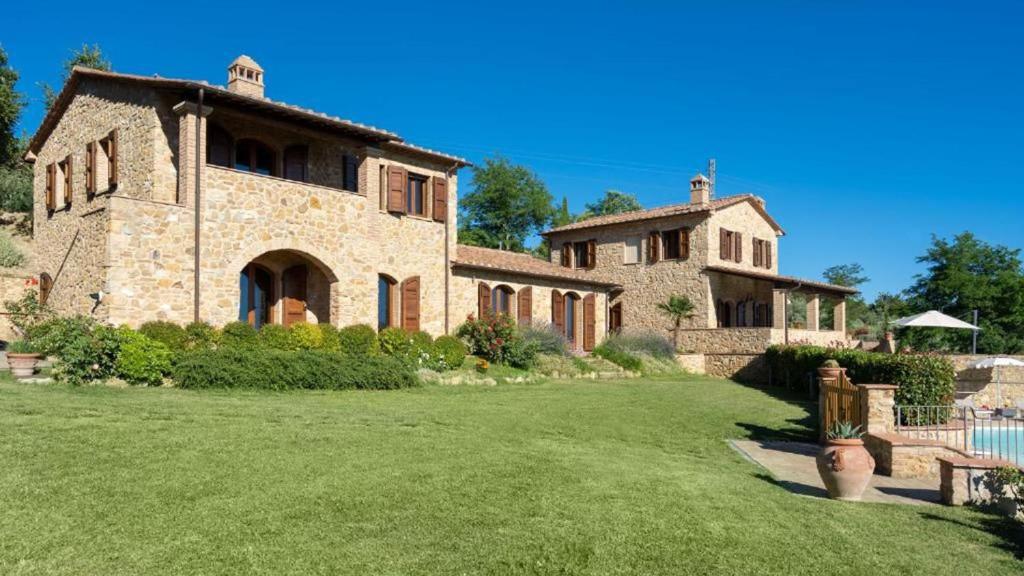 a large stone house with a large yard at Casale con vista colline in Volterra