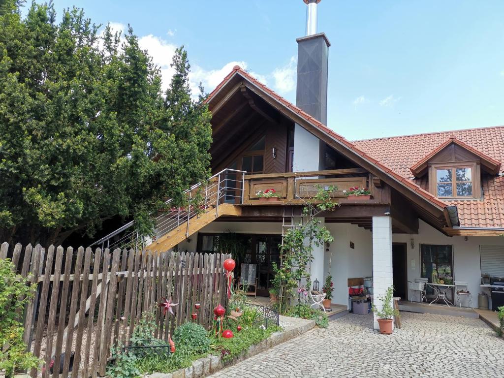 een huis met een houten hek ervoor bij Studio und Apartment auf dem Pferdehof in Burgpreppach