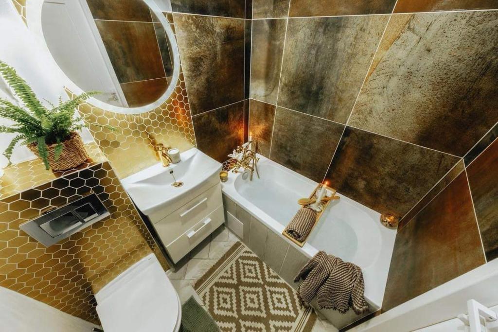 a bathroom with a tub and a toilet and a sink at Siedlisko Farmhouse in Okszów