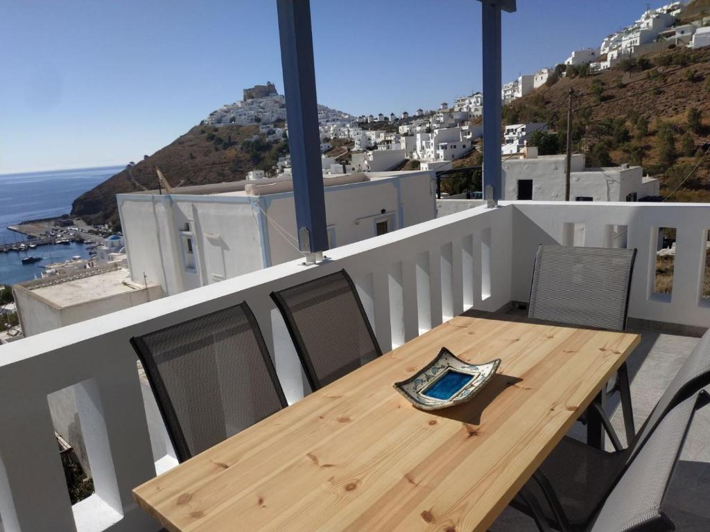 a wooden table and chairs on a balcony with the ocean at Anemoessa House in Pera Gyalos