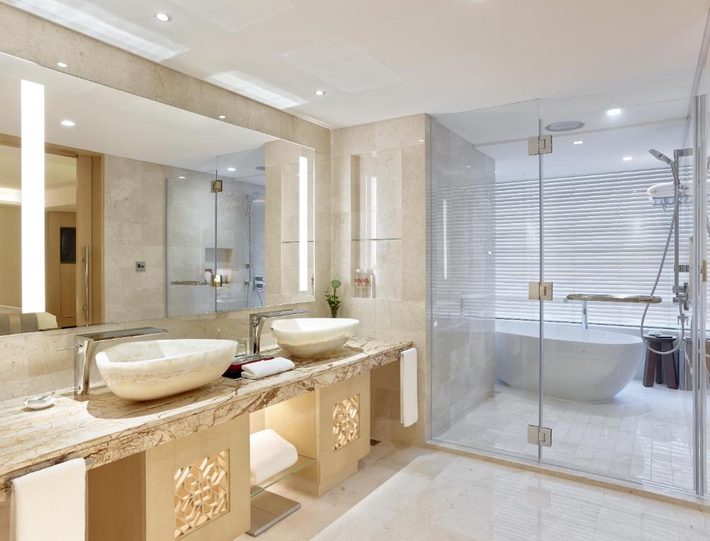 two sinks in a bathroom with a shower and a tub at White Swan Hotel in Guangzhou