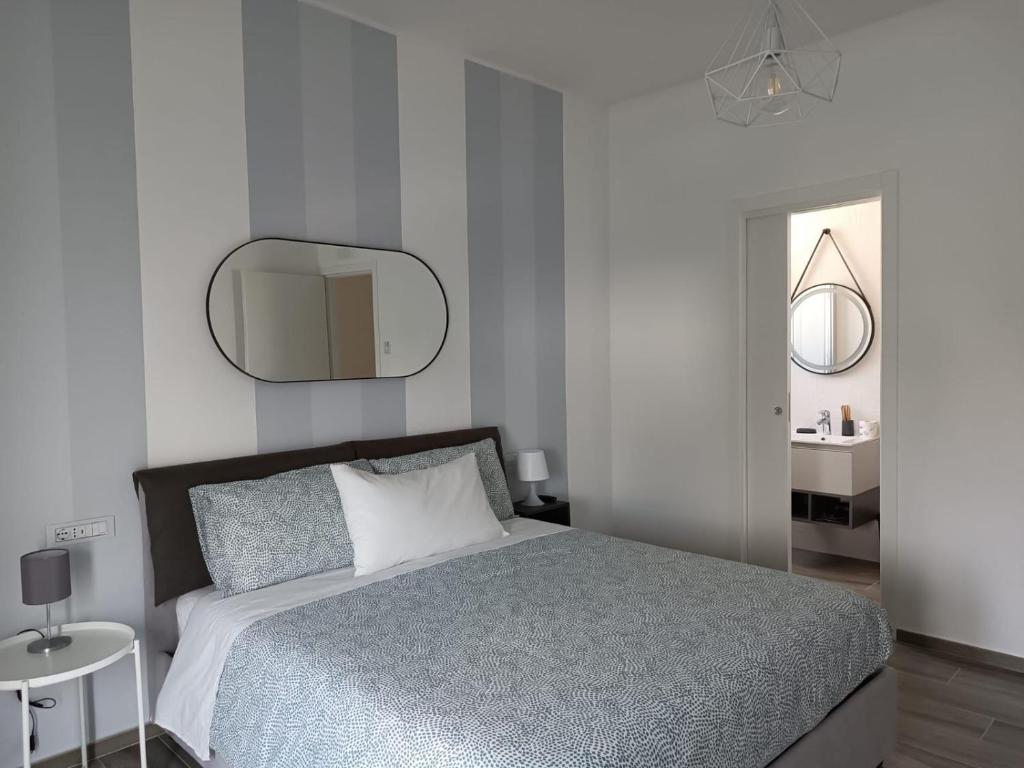 Un dormitorio con una cama grande y un espejo. en CASA AL MARE LUXURY, en Bari