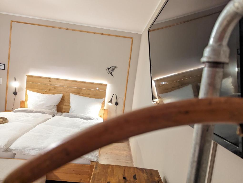 - une chambre avec un lit et un miroir dans l'établissement Spechtnest, à Naumbourg