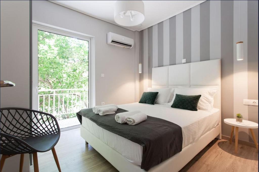 um quarto com uma cama grande e uma janela em Koukaki Urban and Cozy Apartment em Atenas