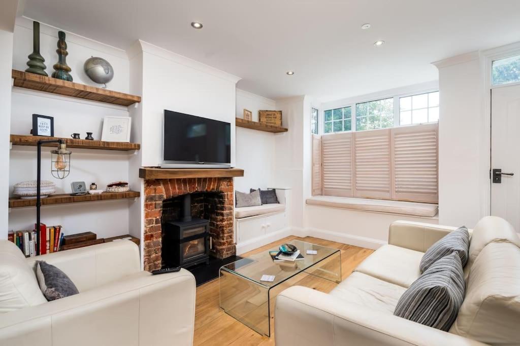 ein Wohnzimmer mit einer weißen Couch und einem Kamin in der Unterkunft Beautiful 3 bed Cottage Chorleywood. in Chorleywood