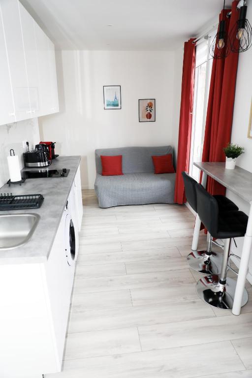 - une cuisine avec une table et un canapé dans une chambre dans l'établissement Eiffel Tour Cosy terracota, à Paris
