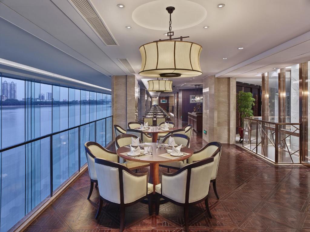 a dining room with a table and chairs and a large window at White Swan Hotel in Guangzhou