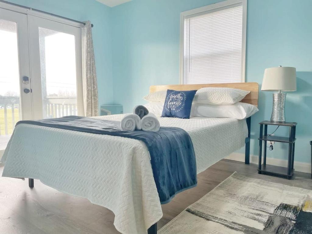 um quarto azul com uma cama com toalhas em Housepitality - The Bliss Lodge - Large House em Columbus