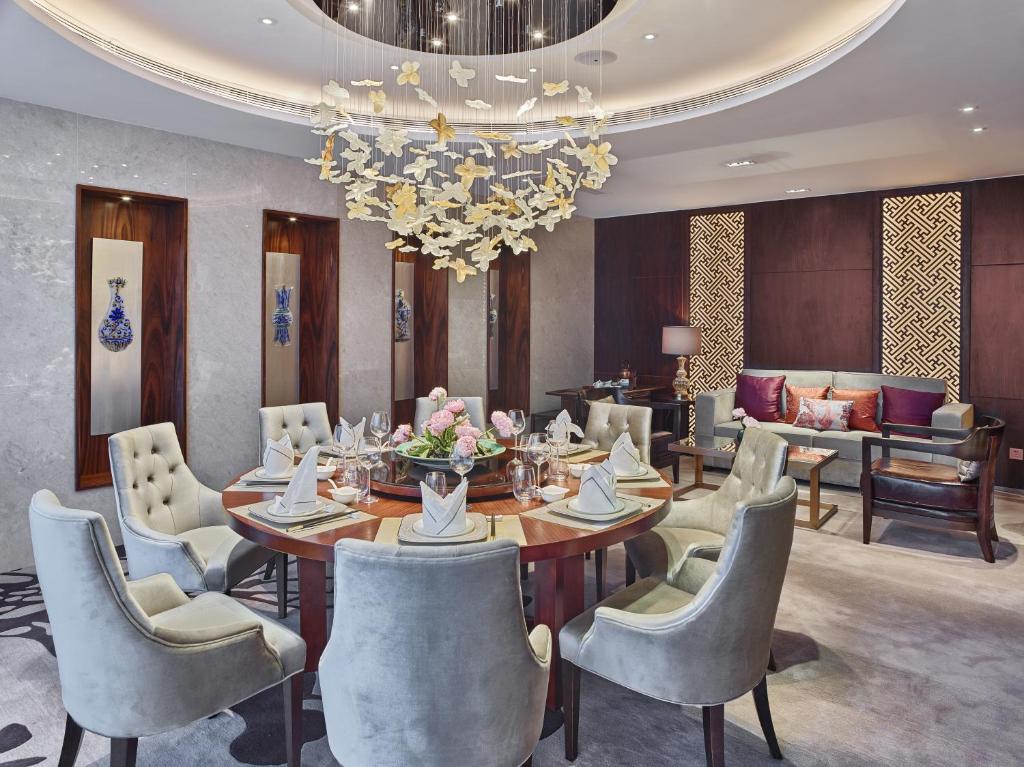 a dining room with a table and chairs and a chandelier at White Swan Hotel in Guangzhou