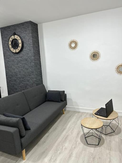 - un salon avec un canapé et une horloge murale dans l'établissement Appartement Dunkerque, à Dunkerque