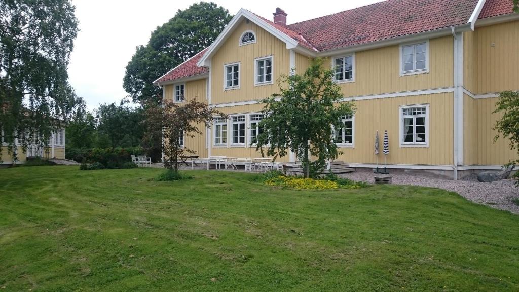 a large yellow house with a large yard at Salnö Gård in Bylehamn