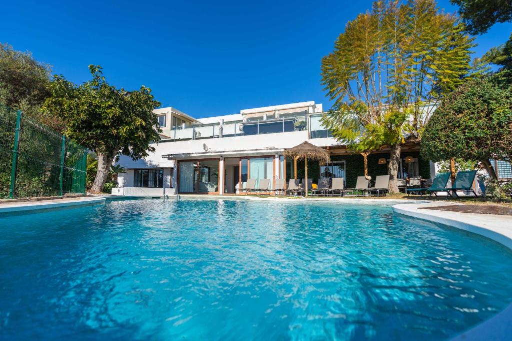 a swimming pool in front of a house at Casa Rio Real Marbella in Marbella