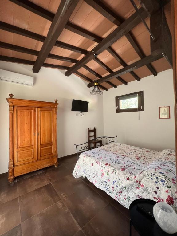 een slaapkamer met een bed en een houten kast bij Agriturismo La Vergheria in Macchiascandona