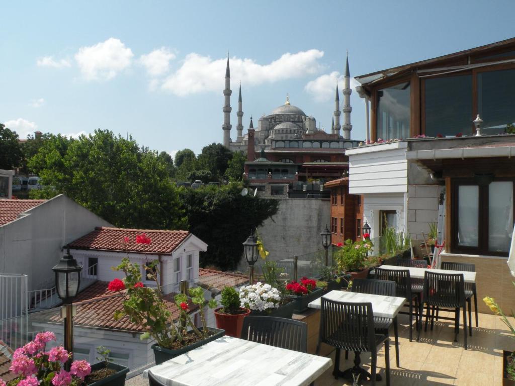 a balcony with tables and chairs and a view of a mosque at Agora Boutique Hotel & Bistro in Istanbul