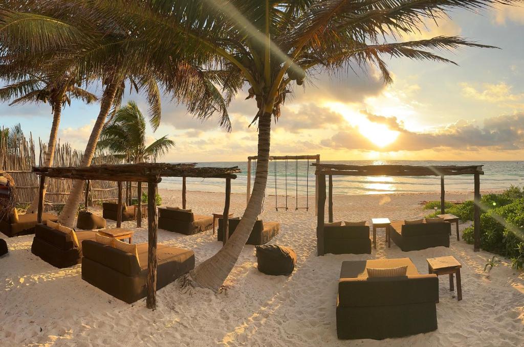 圖盧姆的住宿－Sivana Tulum，海滩上设有椅子、帐篷和棕榈树