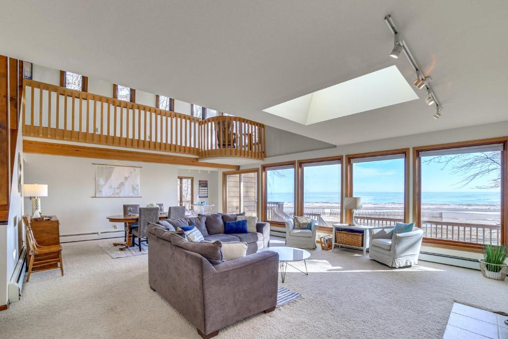 sala de estar con sofá, sillas y ventanas en Lake Michigan Home with Private Beach and Deck!, en Menominee
