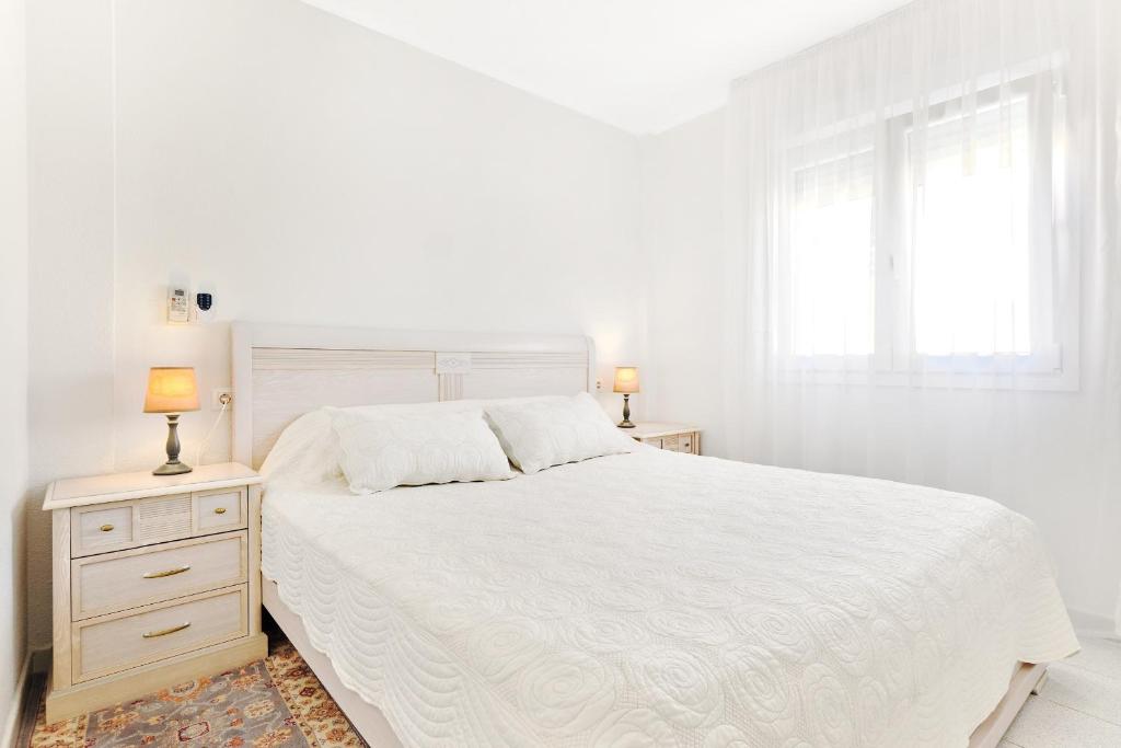 Un dormitorio blanco con una cama blanca y una ventana. en Sea view apartments Dunas de La Mata Torrevieja, en Torrevieja