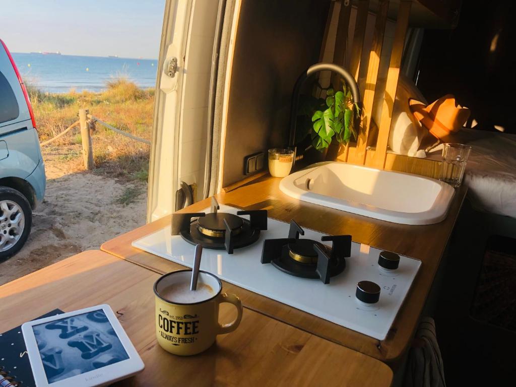 una cocina con fregadero y una taza de café sobre una mesa en Furgoneta camperizada en Playa de las Américas