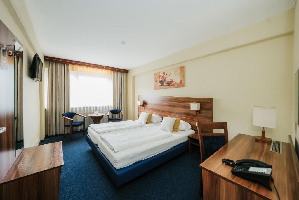 um quarto de hotel com uma cama e uma secretária em Savoy Hotel em Frankfurt