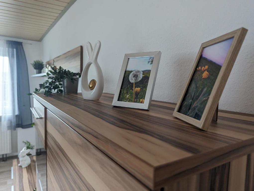 a wooden counter with three pictures on top of it at Ferienwohnung Pusteblume in Marktbergel