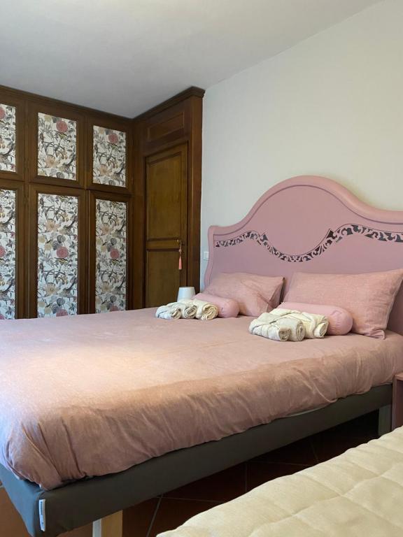 a bedroom with a large bed with a pink headboard at Da Francesca in Lucca