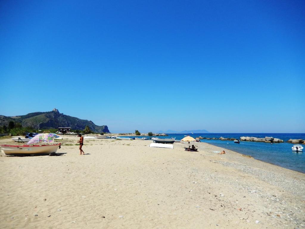 a beach with boats and a person standing on it at Hotel-Pensione 4 Stagioni in Falcone