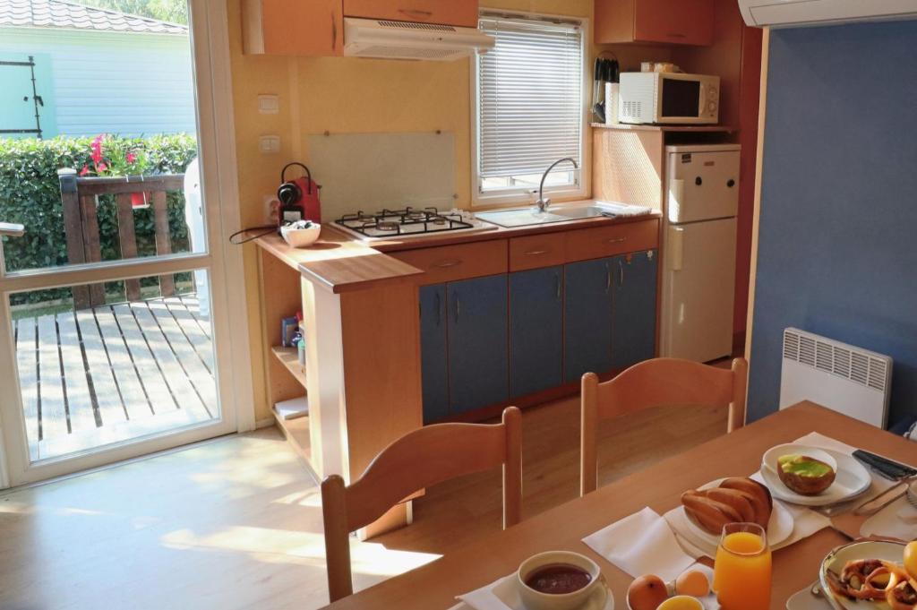 a kitchen with a table with a plate of food on it at Mobilhome LesPins YourHostHelper in Hyères
