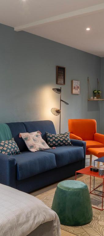 - un salon avec un canapé bleu et une chaise orange dans l'établissement Oslo - Appartement Spacieux et Cosy, à Charleville-Mézières