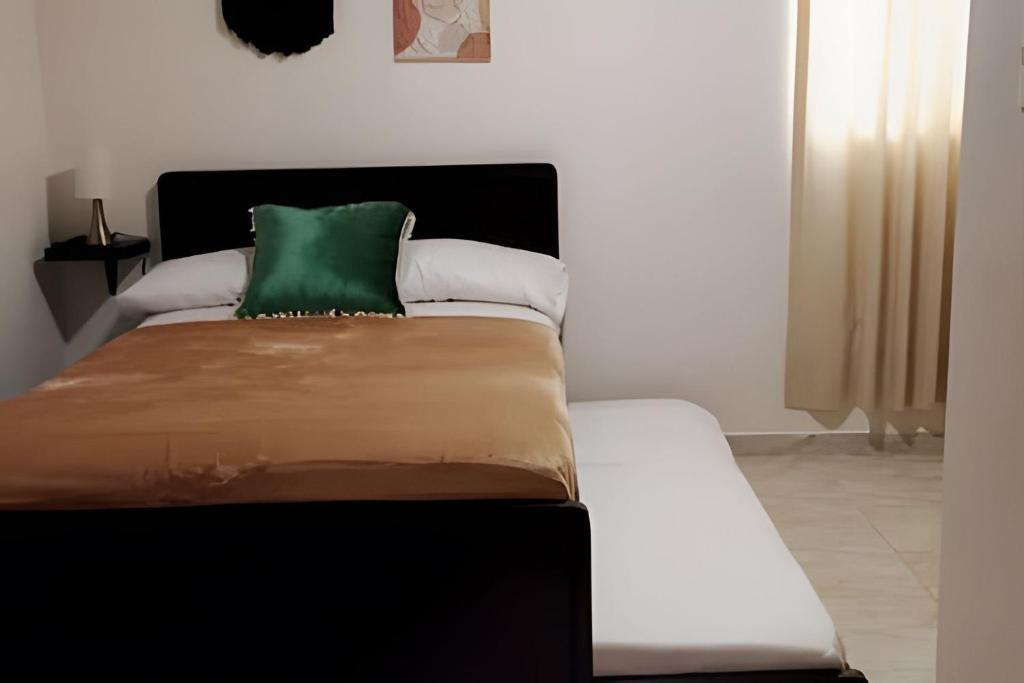 a bed with a green pillow on top of it at GURUS FR | Cerca al CC Arboleda, Circunvalar y Centro in Pereira