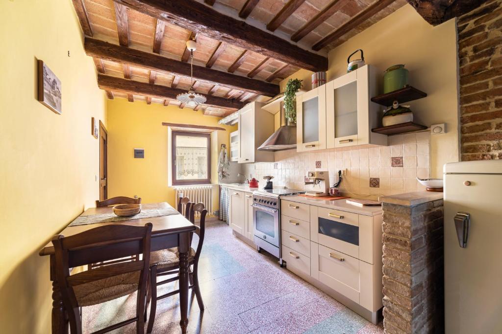een keuken met een tafel en stoelen en een koelkast bij Mi Spiazzi ! in Iesi