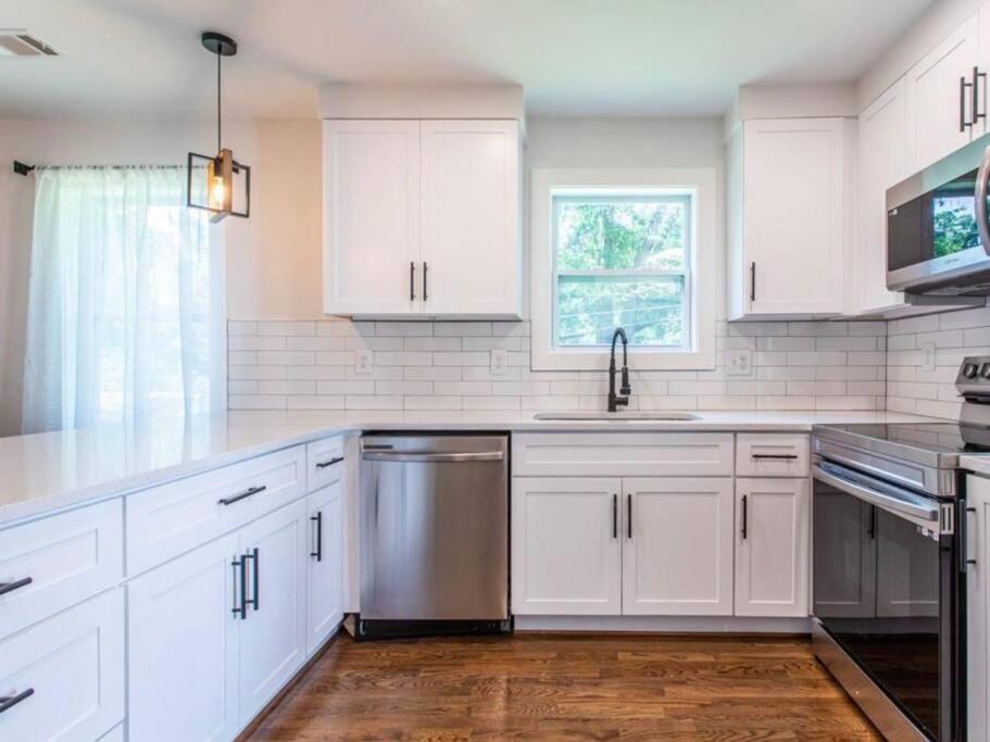 a kitchen with white cabinets and a stainless steel dishwasher at GROVE PARK- ‘Newly Renovated’ home- just mins from Midtown/Downtown Atlanta. in Atlanta