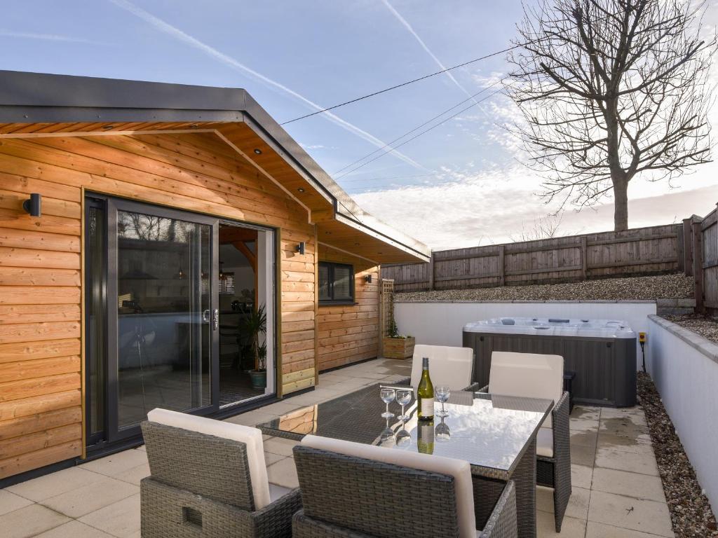 a patio with a table and chairs and a building at The Stables Merrydown in Axminster