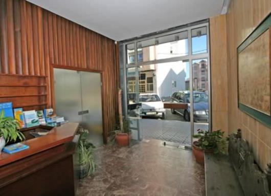 オ・グローベにあるHotel Angelitoのデスクと大きなガラスドア付きのオフィス