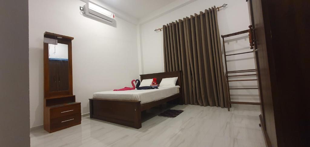 a bedroom with a bed and a dresser and a window at King's Villa Appartement in Matara